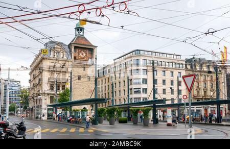 Das Stadtzentrum von Genf mit dem Turm Tour de l'Ile und der Bushaltestelle Bel-Air und der Straßenbahnstation an einem bewölkten Tag. Schweiz. Stockfoto