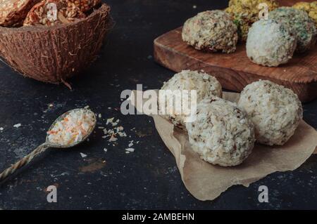 Hausgemachte vegane Schokoladentrüffel Pralinen und Nüsse mischen Zutaten auf dunklem Hintergrund, Draufsicht, Rand. Gesunde Süßigkeiten. Energie vegan Kugeln mit Stockfoto