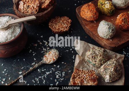 Hausgemachte vegane Schokoladentrüffel Pralinen und Nüsse mischen Zutaten auf dunklem Hintergrund, Draufsicht, Rand. Gesunde Süßigkeiten. Energie vegan Kugeln mit Stockfoto