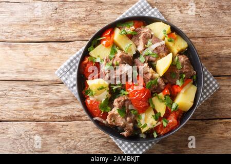 Langsam gekochtes Khaschlama aus Fleisch mit Gemüse aus nächster Nähe in einem Teller auf dem Tisch. Horizontale Draufsicht von oben Stockfoto