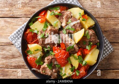 In einer Schüssel auf dem Tisch stauen Armenier und Georgian Khashlama Fleisch mit Gemüse aus nächster Nähe. Horizontale Draufsicht von oben Stockfoto