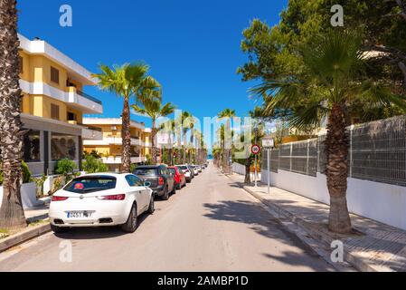 CAN Picafort, Mallorca - 10. Mai 2019: Eine schöne Straße mit Palmen, die zum Meer in Can Picafort führt. Balearen, Spanien Stockfoto