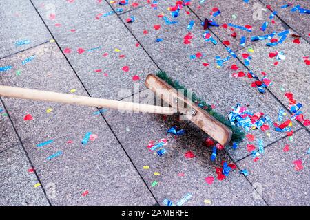 Mehrfarbige Glitzerscheiben auf dem Straßenbelag nach dem Urlaub saubere Wischtücher. Die Arbeit des Müllsammlers. Stockfoto