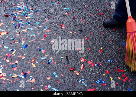 Mehrfarbige Glitzerscheiben auf dem Straßenbelag nach dem Urlaub saubere Wischtücher. Die Arbeit des Müllsammlers. Stockfoto