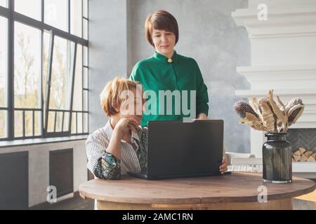 Zwei Frauen, die ein Notebook arbeiten (40 und 60 Jahre alt) Stockfoto