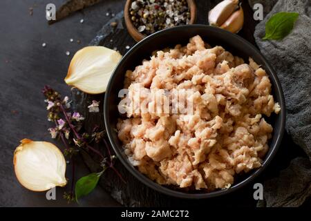 Hackfleisch und Zutaten zum Kochen von Hackfleisch in einer Schüssel auf Schiefer. Stockfoto