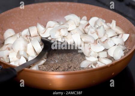 Gemahlenes Hackfleisch und Champignons in Bratpfanne Stockfoto