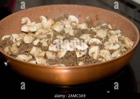 Gebräuntes Hackfleisch und Champignons in Bratpfanne kochen Stockfoto