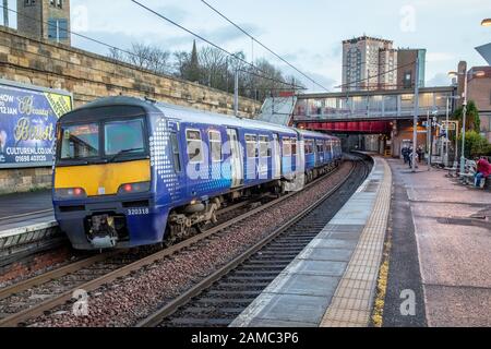 Ein Scotrail-Elektrozug der Klasse 320 auf Bahnsteig 1 des Bahnhofs Motherwell, während der Zug nach Lanark fährt. Die Gerätenummer lautet 320318 Stockfoto