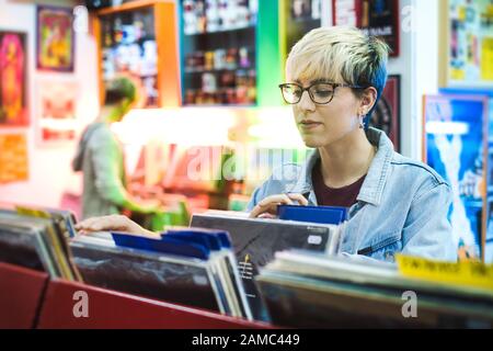 Junge Frau Wahl Vintage Vinyl LP In Records Shop Stockfoto