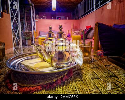 Frischer Minztee in typischen Tee-Metalltöpfen und -Gläsern in einem Restaurant in Marrakesch, Marokko. Es handelt sich um einen typischen Berbertee, der auch Berber-Whisky genannt wird. Stockfoto