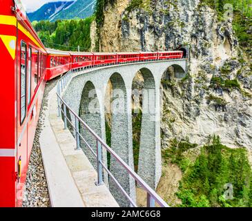 Die Rhätische Bahn von St. Moritz nach Chur ist gerade Filisur verlassen und führt über den berühmten Landwasser-Viadukt in der Schweiz Stockfoto