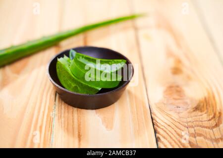 Aloe vera in Tasse auf leerem Holztisch in Nahaufnahme Stockfoto