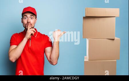 Courier hat eine streng geheime Information zu enthüllen. Emotionaler Ausdruck. Hintergrund Zyan Stockfoto