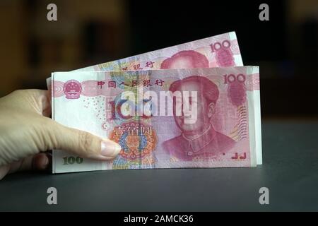 Hand, die einen Haufen von 100 chinesischen Yuan-Banknoten hält. China Currency Concept. Stockfoto