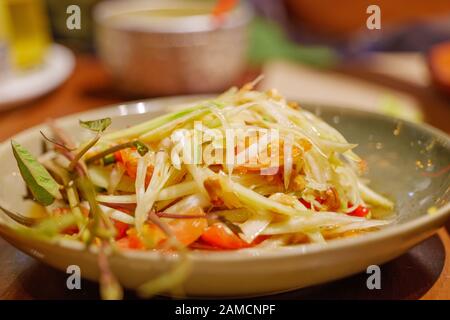 Nahaufnahme von thailändischem würzigen grünen Papaya-Salat, Som Tum, mit trockenem Garnelen. Stockfoto