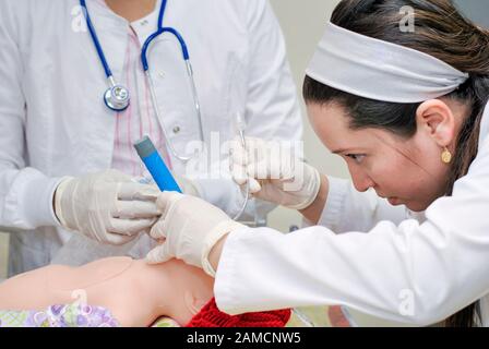 Ärzte, die eine endotracheale Intubation im Puppensimulator von Säuglingen durchführen. Pädiatrisches Krankenhaus. Guayaquil. Ecuador Stockfoto