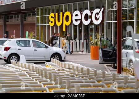Reihen von gelben Einkaufswagen (Warenkarren) in einem SUPECO-Supermarkt in Frankreich. Stockfoto