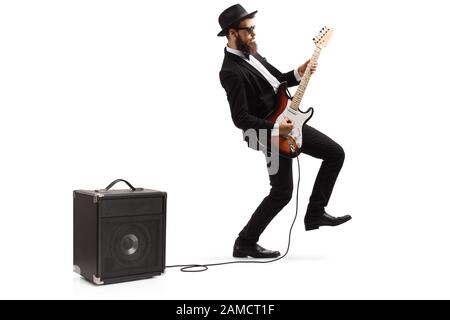Lange Aufnahme eines bärtigen männlichen Künstlers in einem Anzug, der eine verstopfte E-Gitarre spielt, die auf weißem Hintergrund isoliert ist Stockfoto