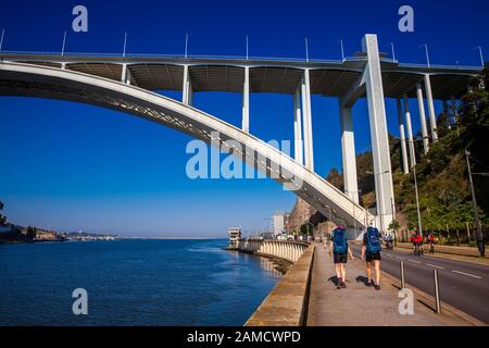Porto, PORTUGAL - MAI 2018: Touristen und Einheimische, die einen schönen frühen Frühlingstag neben dem Fluss Douro und der Arrabida-Brücke in Porto City i genießen Stockfoto