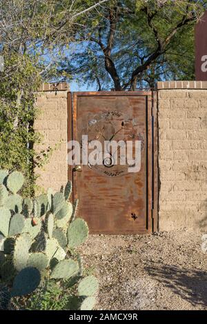 Rost farbigen distressed Metal Gate in Adobe Wand der seitlichen Garten renovierte Haus zeigt die Gentrifizierung in gentrifying Barrio Historic District Tucson Stockfoto