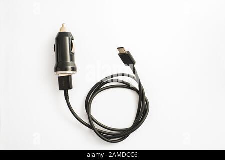 Das schwarze Auto Ladegerät mit USB-Ausgang Anschlusskabel. Ein Foto auf einem schwarzen Auto Ladegerät mit USB-Ausgang Anschlusskabel gegen einen weißen Hintergrund genommen Stockfoto