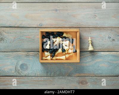 Schachfiguren in Holzbox mit dem König außerhalb der Box Stockfoto