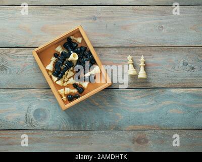 Schachfiguren in Holzbox mit dem König und der Königin, außerhalb der Box Stockfoto
