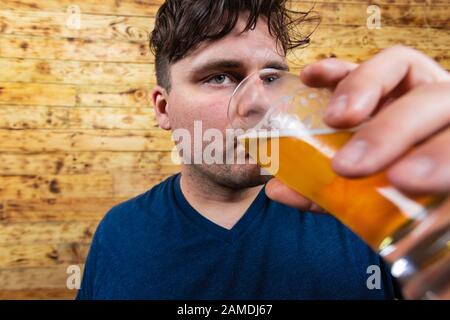 Portrait von nachdenklichen Männern, die Bier trinken. Männer trinken Bier. Gutaussehende junge Männer, die Bier trinken und träumen. Stockfoto