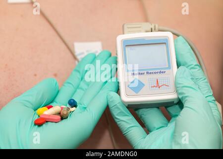 Die Hand des Arztes, der holter-herzmonitor auf die Brust eines jungen Mannes aufgibt Stockfoto