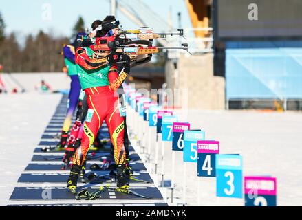 Les Rousses, Frankreich. Januar 2020. Gou Zhendong (vorne) aus China tritt im Biathlon-Einzel-Mixed-Staffel bei den 3. Olympischen Winter-Olympischen Spielen im Les Tuffes Nordic Centre in Les Rousses, Frankreich, 12. Januar 2020 an. Credit: Shan Yuqi/Xinhua/Alamy Live News Stockfoto