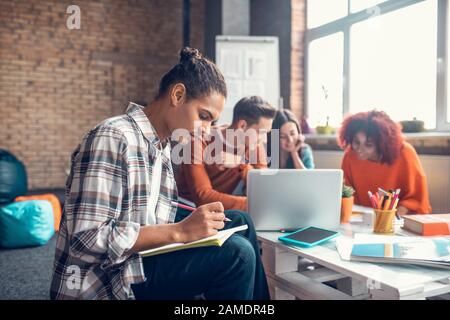 Eine Gruppe von Studenten, die am Tisch sitzen und sich auf Prüfungen vorbereiten Stockfoto