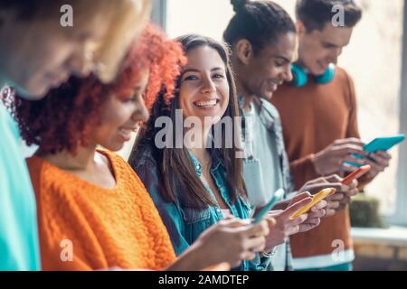 Studenten, die Telefone verwenden und Spiele spielen, während sie eine Pause vom Studium hatten Stockfoto