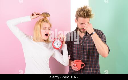 Leider spät Regime. Paar Morgen erwachen Wecker. Gesunde rest Regime genug zum Schlafen. Wir sollten gehen Sie früher ins Bett. Frau und Mann sleepy zerzaustem Haar trinken Kaffee am Morgen. Stockfoto