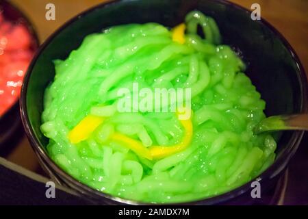 Cendol, geschwollener grüner, wurmähnlicher Jelly-Snack, aus Reismehl und anderen Zutaten, die dann durch Filter gebildet und mit Palmenzucker und Kokosnuss gemischt werden Stockfoto