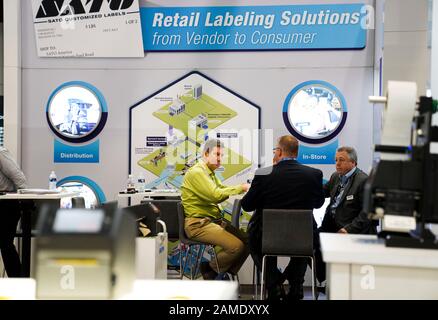 (200113) -- NEW YORK, 13. Januar 2020 (Xinhua) -- Menschen werden auf einem Stand für Labeling-Lösungen für den Einzelhandel auf Der NRF 2020 Vision gesehen: Retail's Big Show, abgehalten in New York, den Vereinigten Staaten, 12. Januar 2020. Über 800 Unternehmen aus fast 100 Ländern und Regionen versammelten sich hier am Sonntag zur jährlichen expo der U. S. National Retail Federation (NRF), die globalen Brancheninsidern neue Ideen, Perspektiven und Technologien bietet. Die NRF-Vision 2020: Die große Messe des Einzelhandels erwartet, dass rund 38.000 Menschen, darunter Aussteller, Branchenbesucher, Experten und Sprecher, in die Jacob K. Javits strömen Stockfoto