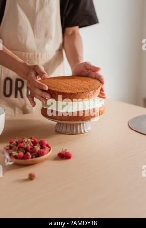 Pastry Chef setzt Kuchen Schicht auf einem Kuchen. Die kuchen Prozess Stockfoto