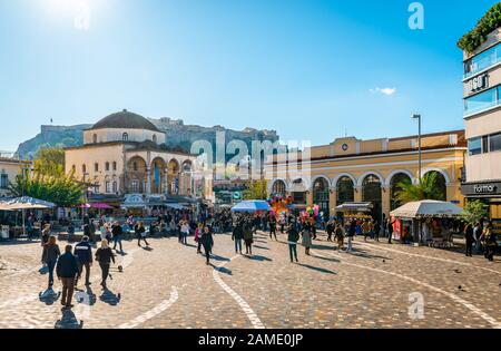 Blick auf den Monastiraki-Platz, auf der linken Seite die Tzistarakis-Moschee und auf der rechten Seite die U-Bahn-Station. Die Akropolis von Athen steht im Hintergrund. Stockfoto