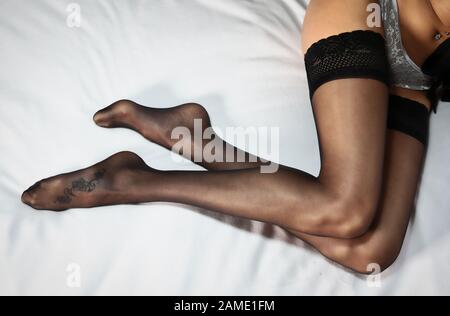 Beine bedeckt von einem Paar schwarzer Strümpfe Stockfoto