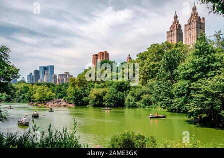 NYC, NY/USA - 12. Juli 2014: Menschen Reihen sich im Central Park mit der Skyline von West Side Manhattan im Hintergrund. Stockfoto