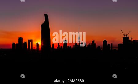 Sonnenuntergang in Kuwait-Stadt - Silhouttes von Wolkenkratzern und Gebäuden Stockfoto