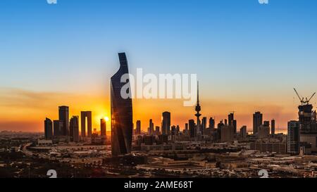 Sonnenuntergang in Kuwait-Stadt - Hell - Stadt, die im Abendlicht leuchtet Stockfoto