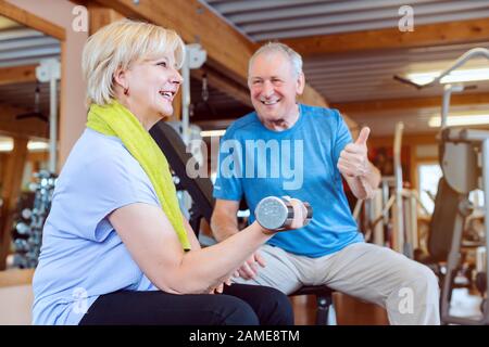 Seniorin im Fitnessstudio trainieren mit Hanteln für Fitness Stockfoto