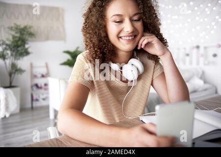 Lächelndes Teenager-Mädchen in ihrem Zimmer Stockfoto