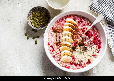 Haferbrei Haferbrei mit Beeren, Erdnussbutter, Banane und chia in einer weißen Schüssel. Stockfoto