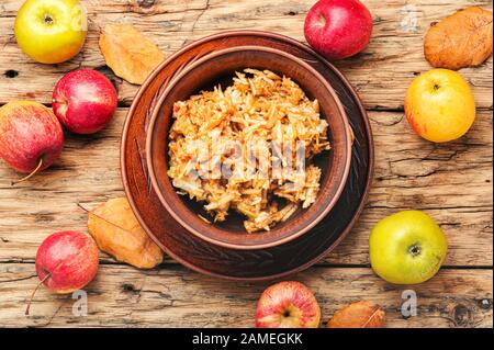 Geriebenen reif Herbst Äpfel in eine Platte auf einem hölzernen alte Tabelle Stockfoto