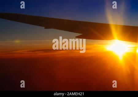 Himmel und Wolken Sonnenuntergang in der Stratosphäre aus Flugzeugfenster abstrakter Hintergrund Stockfoto