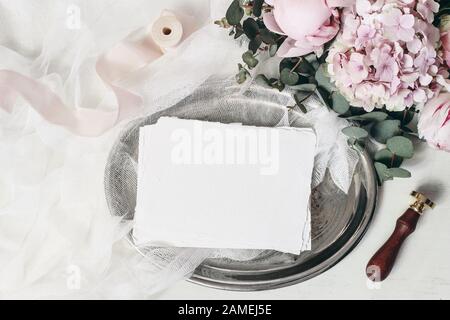 Geburtstagskomposition, Briefpapier verspotts. Hochzeitssgrußkarten auf altem Vintage-Silberteller Eucalyptus, pinke Rosen, Hydrangea, pfironige Blumen, Muslin Stockfoto