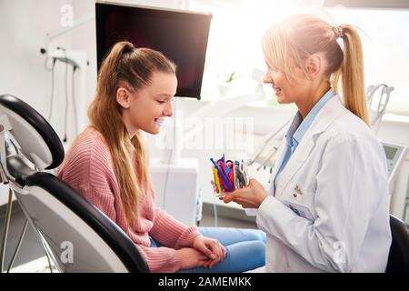 Glückliches Mädchen, das die Farbe der Gummibänder für Hosenträger wählt Stockfoto