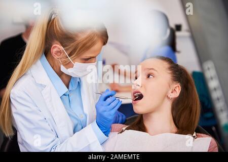 Kieferorthopädin untersucht Zähne des Kindes Stockfoto
